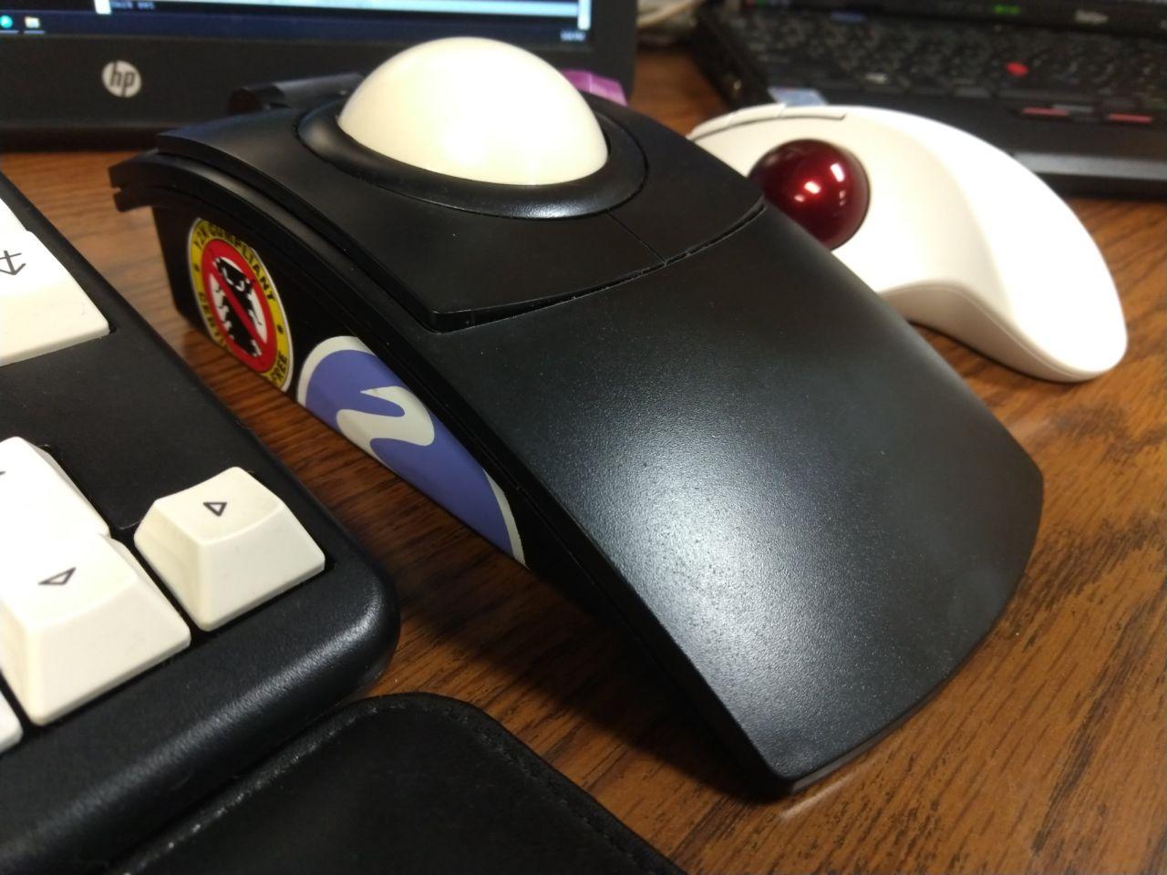 Black L-Trac trackball next to Logitech Ergo M575.