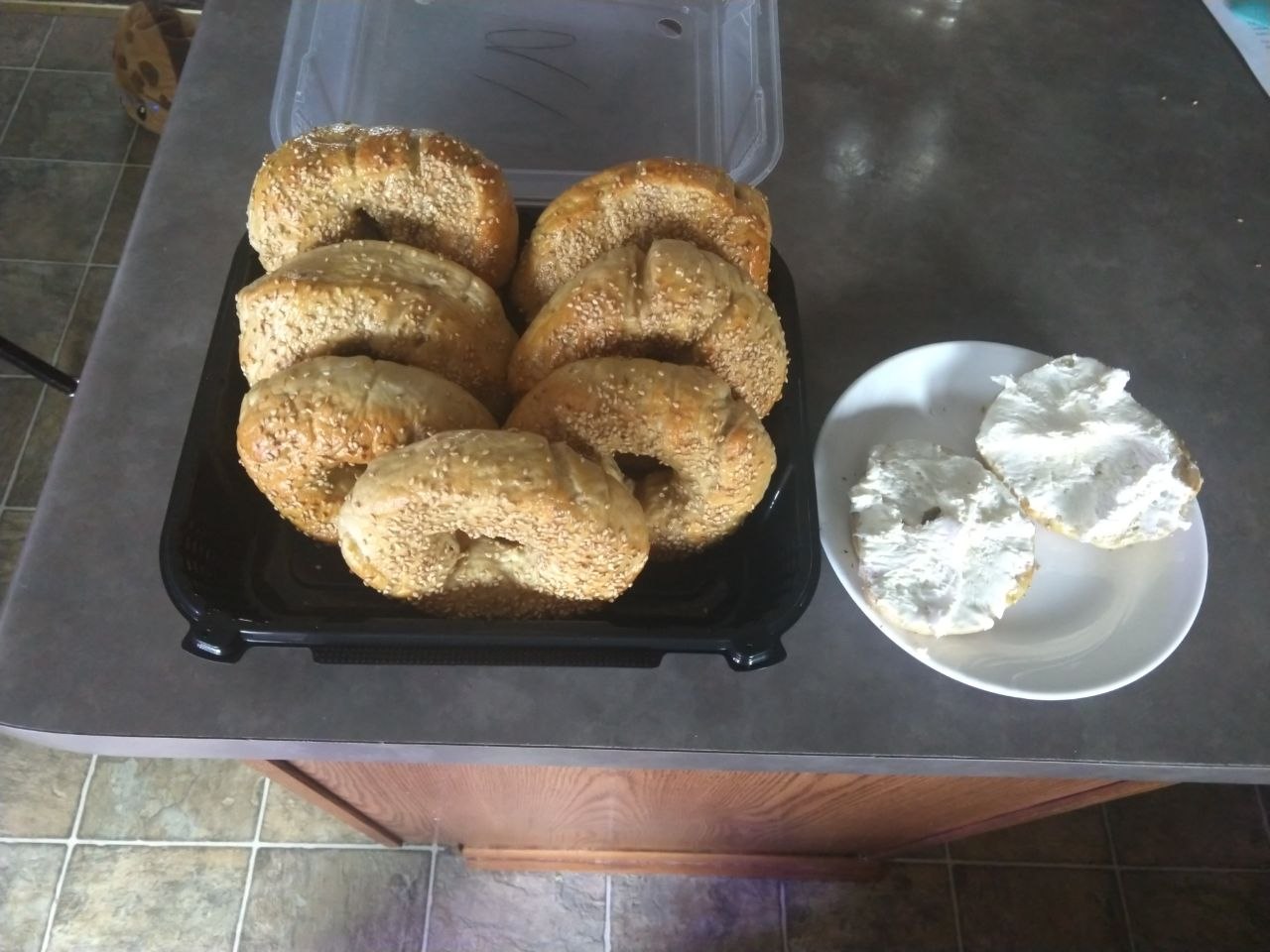 Finished bagels in a box, one is split and toasted with cream cheese.