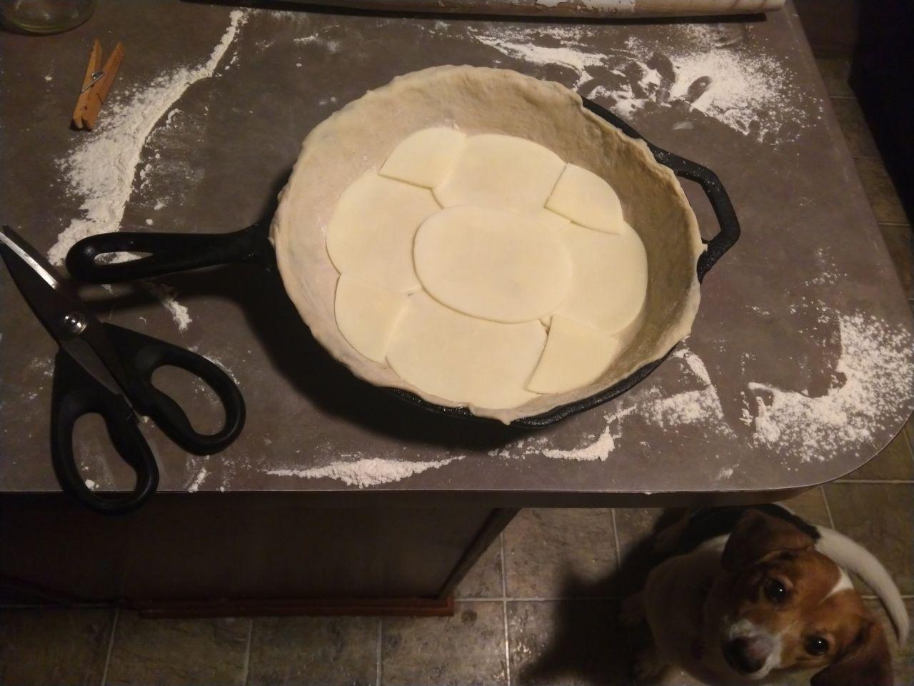 A deep dish pizza made with the same dough recipe. Provolone cheese is laid out on the bottom.