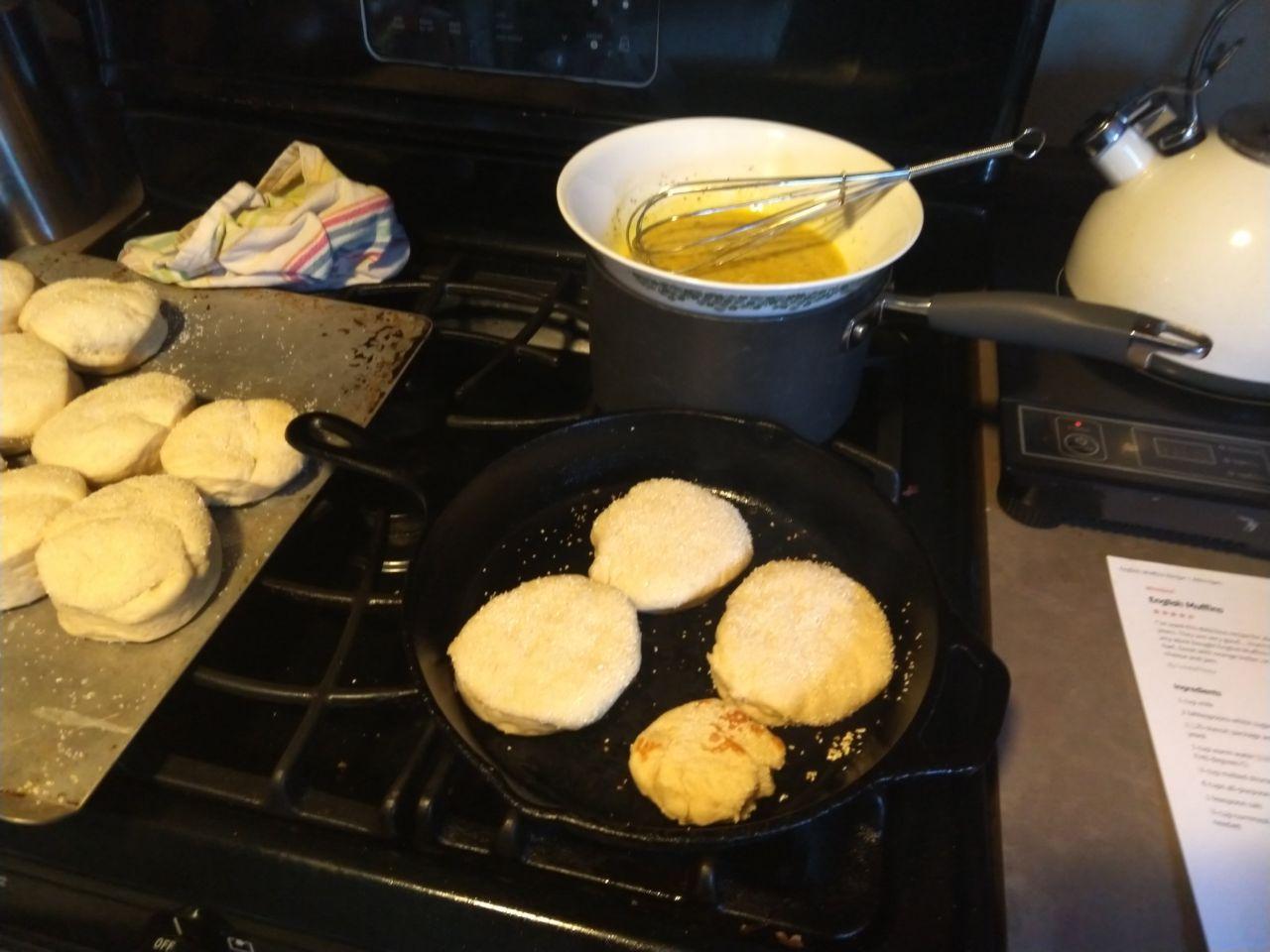 English muffins cooking in a cast iron skillet.