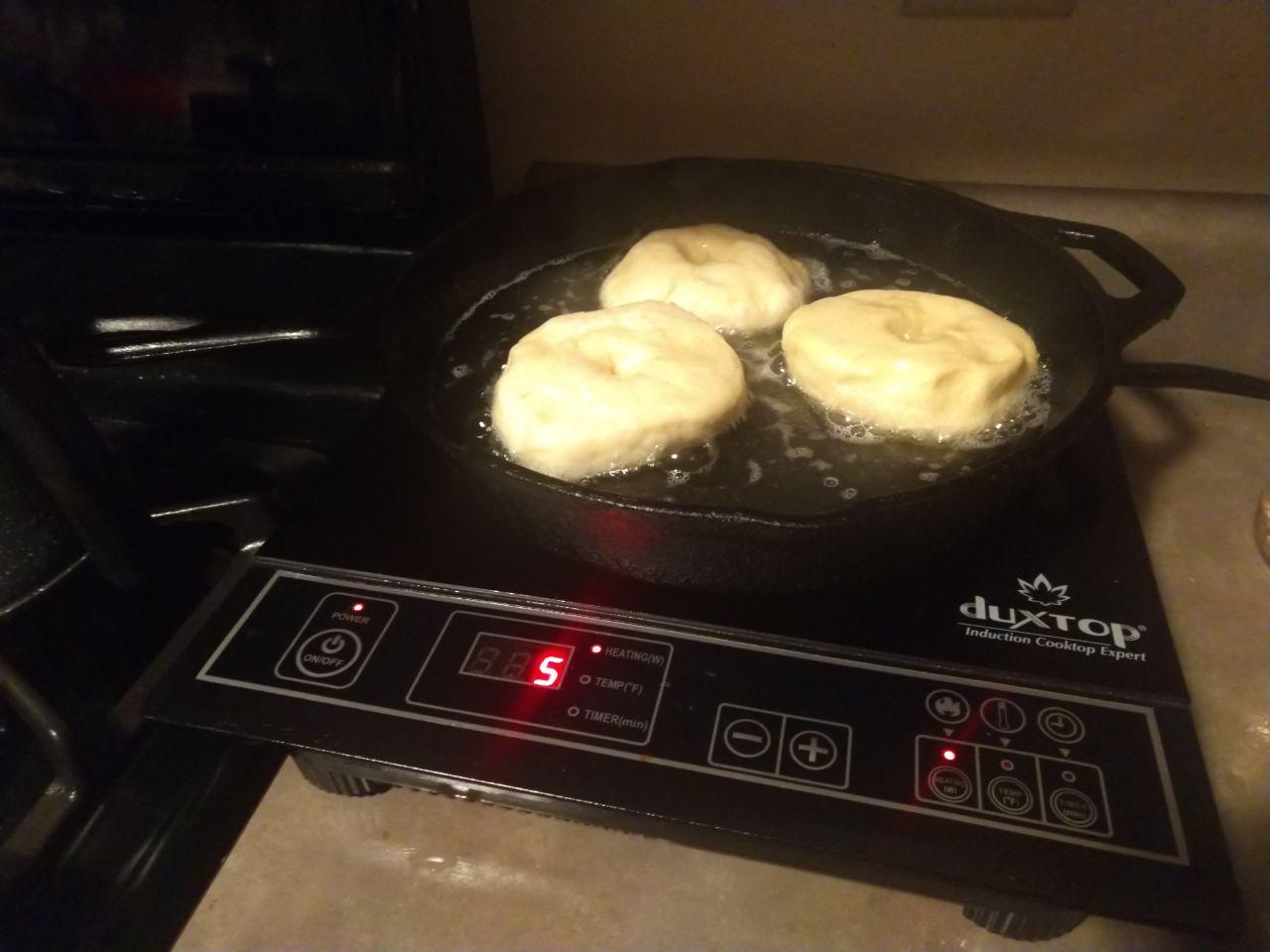 Dontus frying in a cast iron skillet on an induction burner.