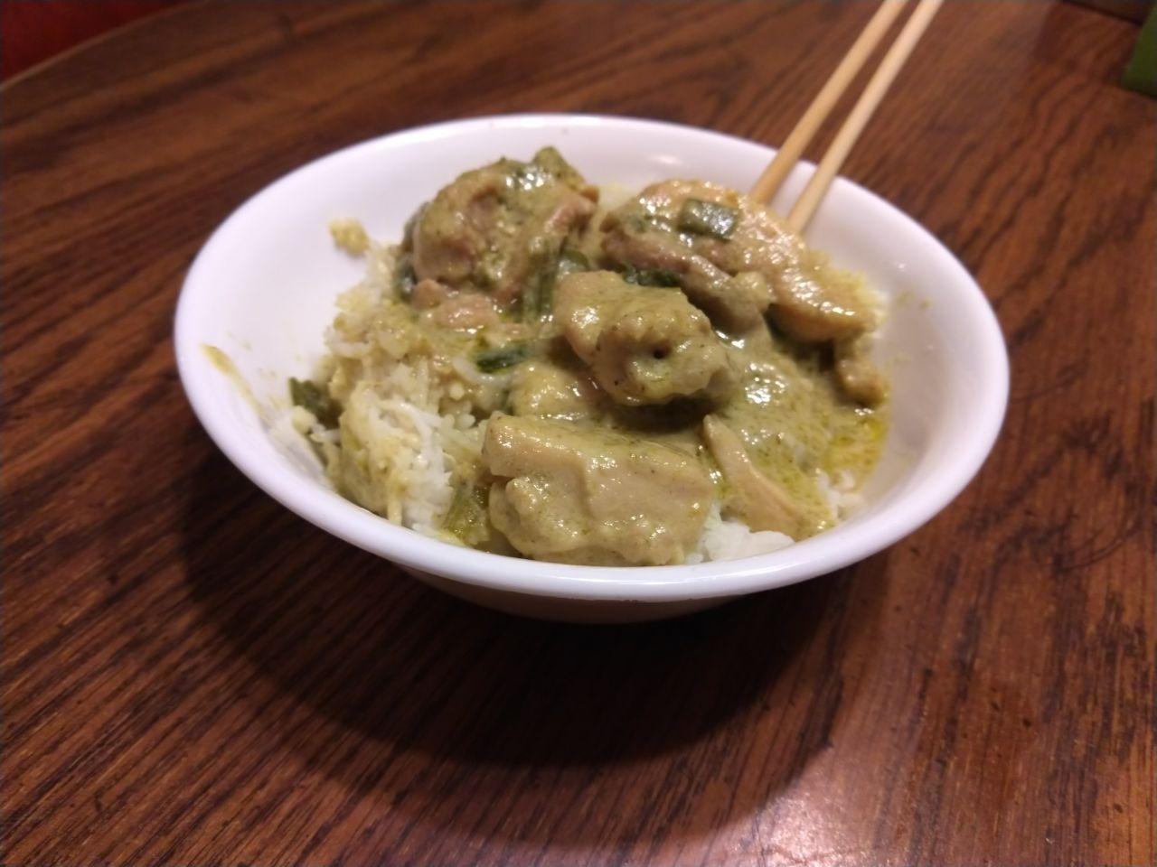 Bowl of green curry on rice.