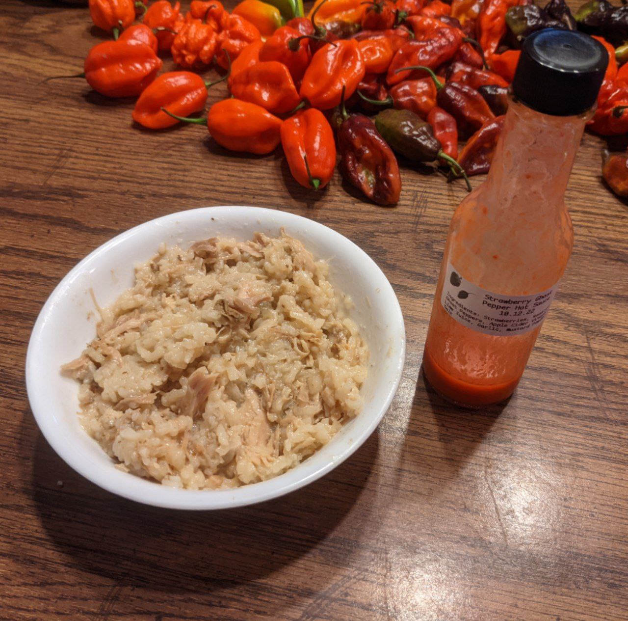 Bowl of turkey jook with hot sauce.