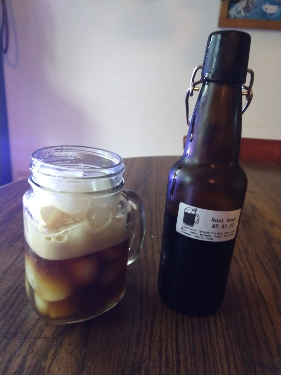 Root beer poured in glass with ice.