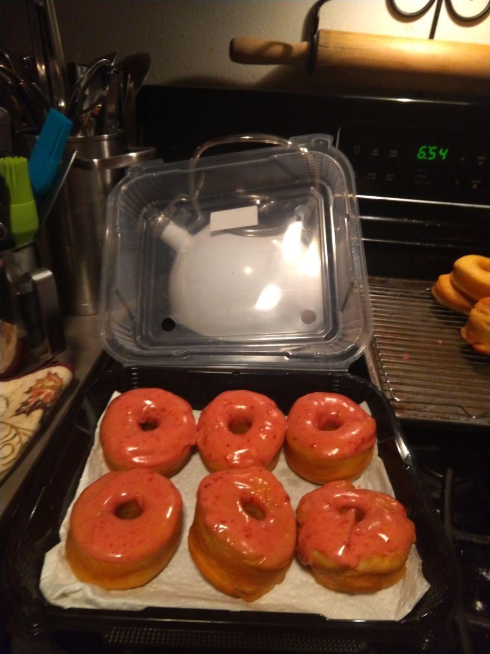 A box of strawberry glazed donuts.