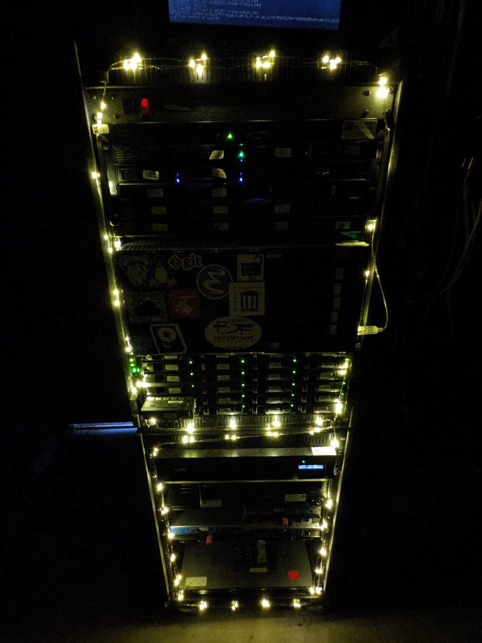 Server rack in a dark room with christmas lights.